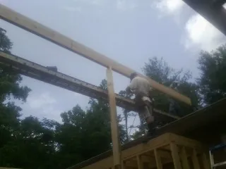 Carpenter setting a ridge beam over a new addition frame — Ice Dam Removal by Roofing Brothers in Victoria